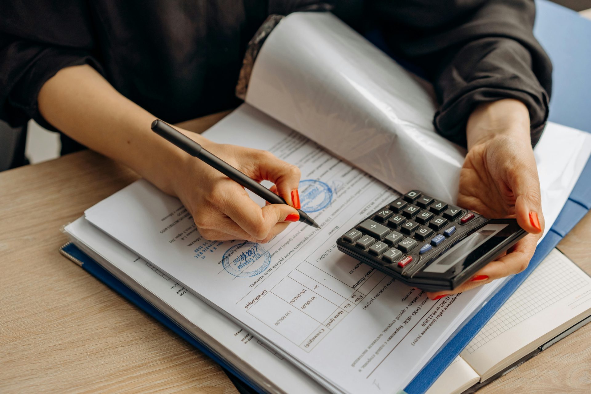 Ein Buchhalter, der einen Taschenrechner benutzt und Dokumente unterzeichnet, präsentiert Finanzanalysen.
