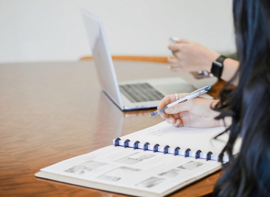 Person mit Stift schreibt auf Papier